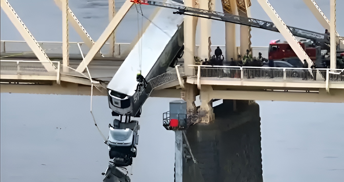 truck falling off side of a bridge over water